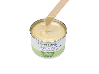 Top view of a dripping sand color hair remover with wooden stick spatula.