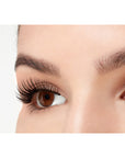 A close-up side shot of a model open right eye wearing Ardell Faux mink 812 showing a rounded, feathery yet natural lash look