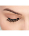 A front view of model with closed eye wearing Ardell Fauxmink Demi Wispies that shows the lash style on the eye