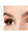 A model wearing Ardell 3D Faux Mink Wispies in a side view emphasizing the curly, flared & natural lash look