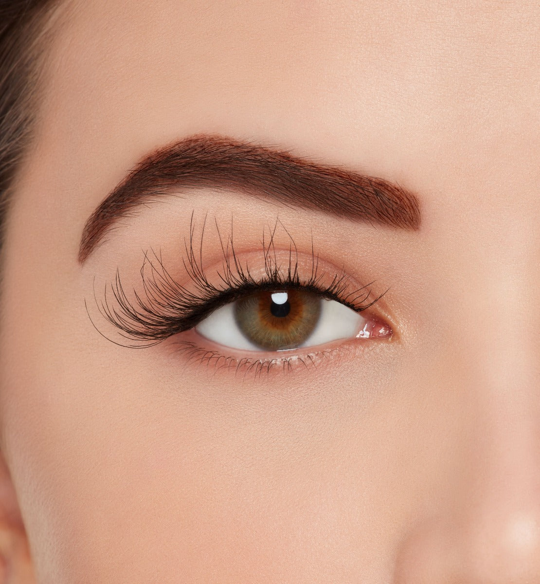 A model wearing Ardell's Wispies 703 to show lightly flared and fluttery lash with an open right eye