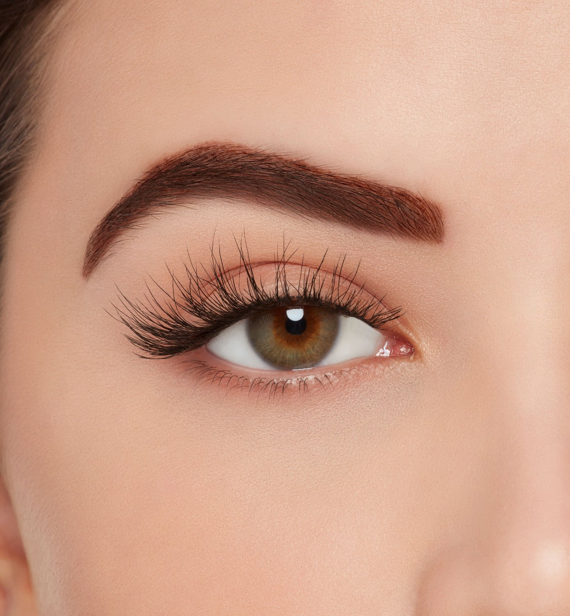 Close-up of a model's open right eye wearing Ardell Wispies 705 false eye lashes