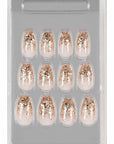 Glittery rose gold gradient press-on nails neatly arranged in a clear packaging case for easy selection.