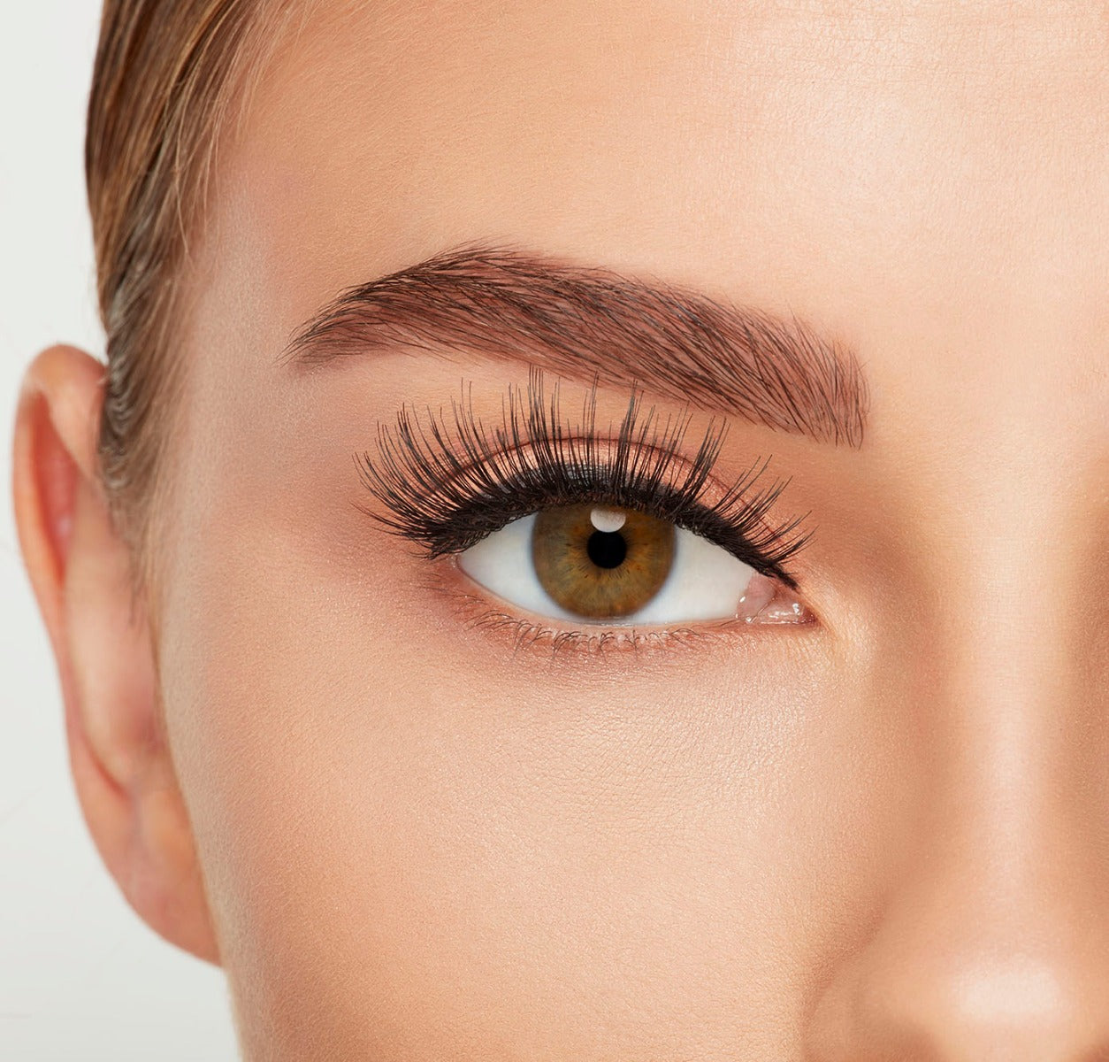 A model wearing Ardell's Double Up 207 with open right eye showing its extra-long layers with intense volume & fullness lash