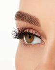 An extreme side close up shot of a model's eye wearing Ardell Double Up 207 creating natural, flared eyelash
