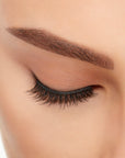 Close-up of a model's closed right eye wearing an Ardell Lift Effect 742 faux lash showing its curled round profile