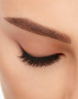 Close-up of a model's closed right eye wearing an Ardell Lift Effect 743 faux lash showing its soft tapered upswept fibers