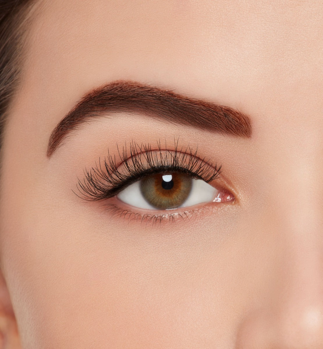 A model wearing Ardell's Ecolashes 454 to show its extra-long, medium volume lash design