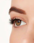 An extreme close-up side shot of a model's eye wearing Ardell's Ecolashes 455 creating A natural, round flared eyelash look