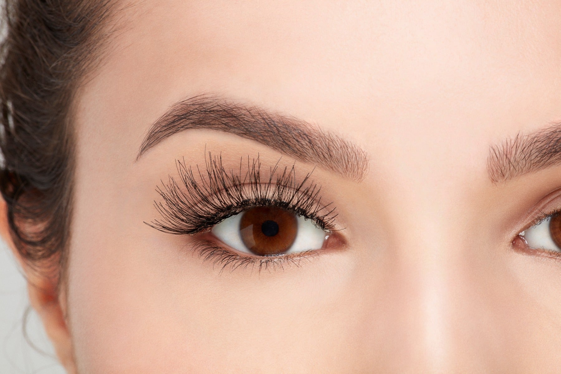 A model with an open right eye wearing Ardel Wispies 113 showing how it looks like when worn