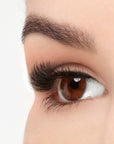 An extreme side close up shot of an eye wearing a Fauxmink 815 by Ardell creating a wide, full & natural eyelash look