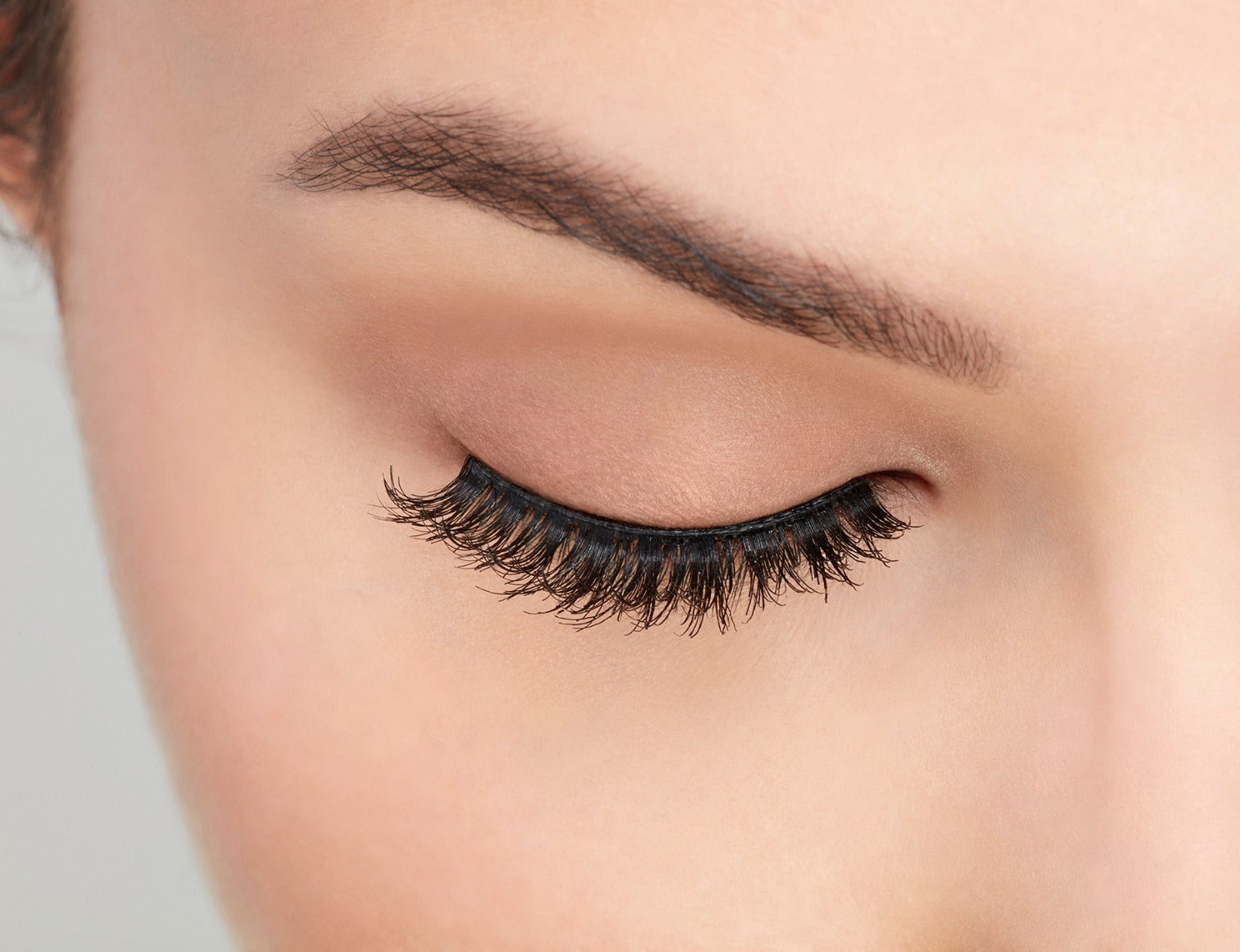 A model with closed eye wearing Ardell Studio Effects 232 with an accented full volume, curl & natural lash look