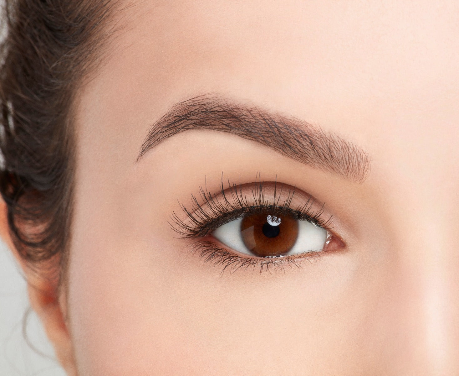 Close-up of a model's open right eye wearing an Ardell Natural 176 false lash