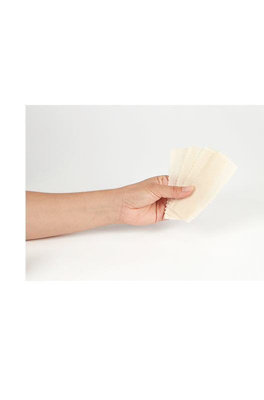 A hand holding a fanned spread of muslin strips