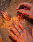 Hand model image putting on shade Dunescape Sand, a red-orange with orange shimmer.