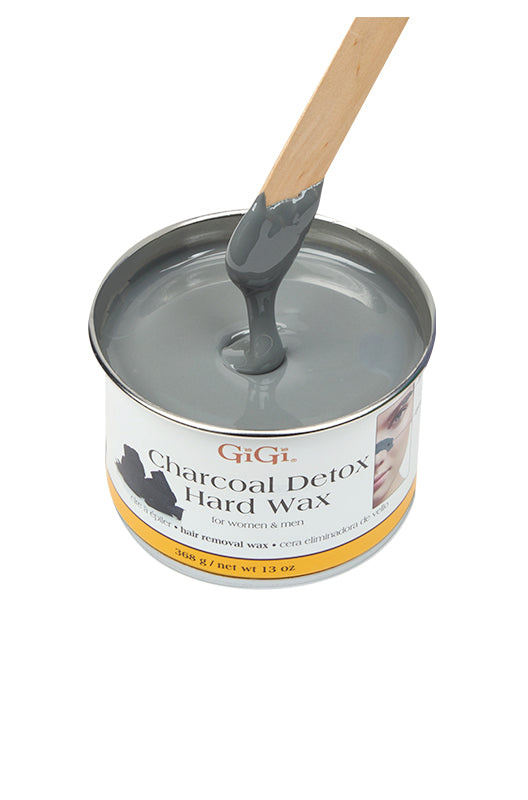 Melted Gigi Charcoal Detox Hard Wax can being drawn out with an applicator to show its charcoal grey color & creamy texture