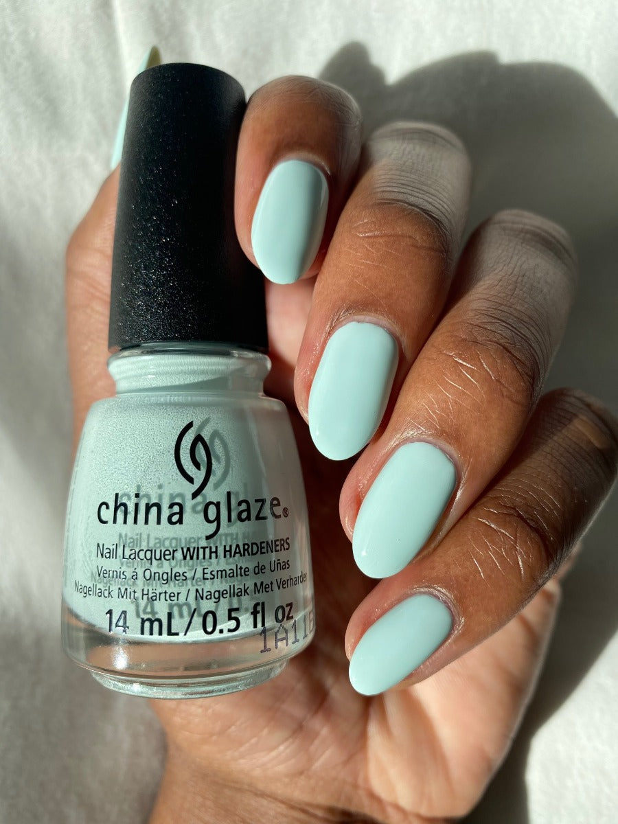 A woman's hand with a glance of 14ml China Glaze nail lacquer with hardeners in Live in the mo-mint color shade