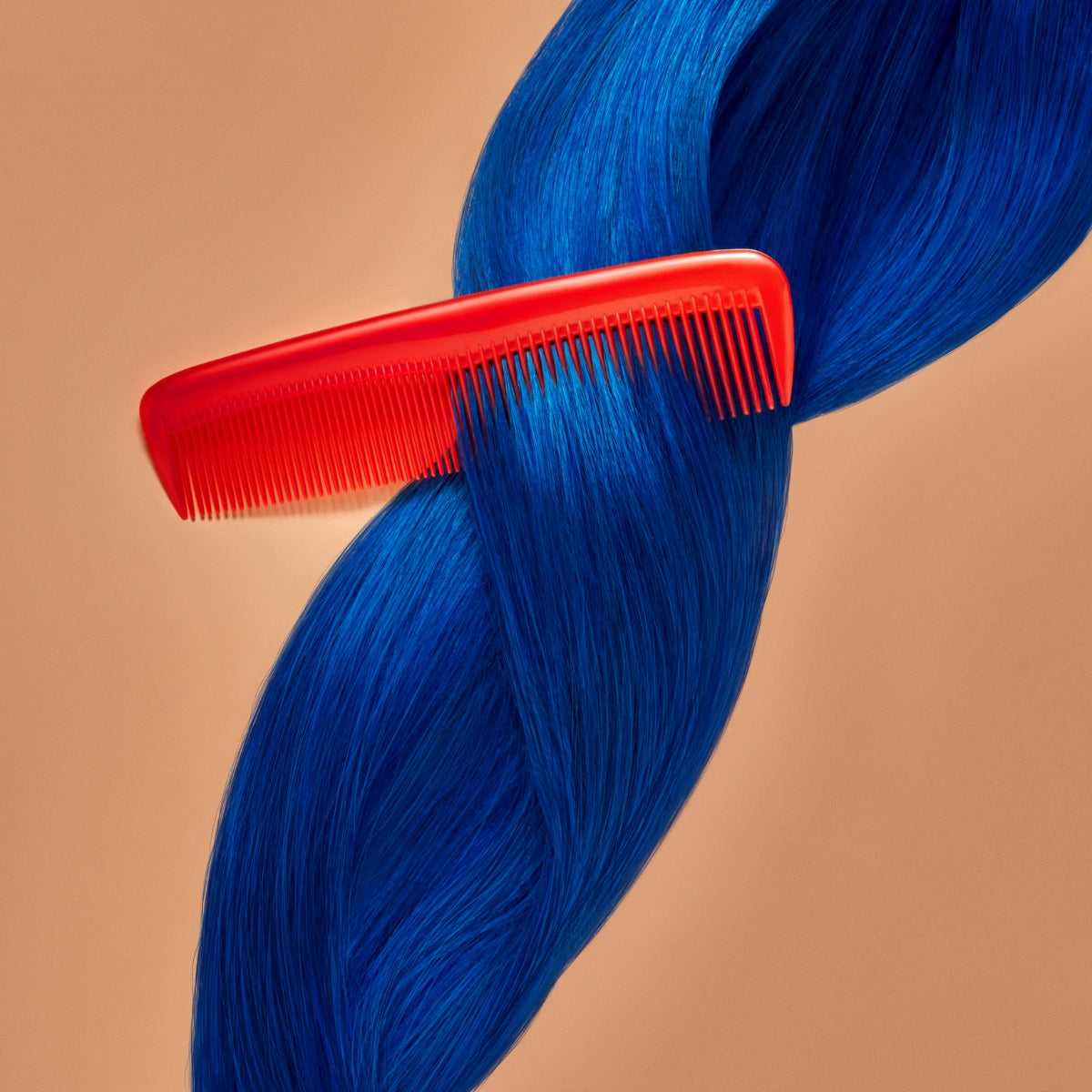 A section of straight, bright blue hair on a orange-brown background being combed, showcasing the Punky Colour Sugar Cloud Jawbreaker Semi Permanent Foam Color