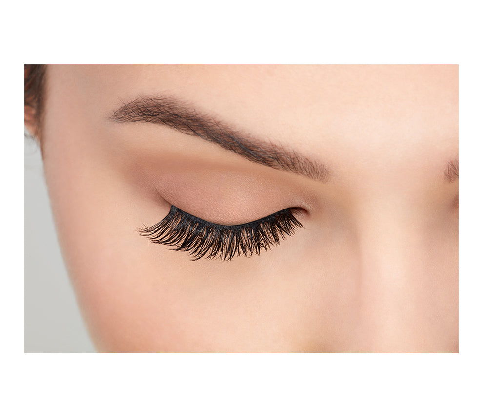 A front view of model with closed eye wearing Ardell Fauxmink Demi Wispies that shows the lash style on the eye
