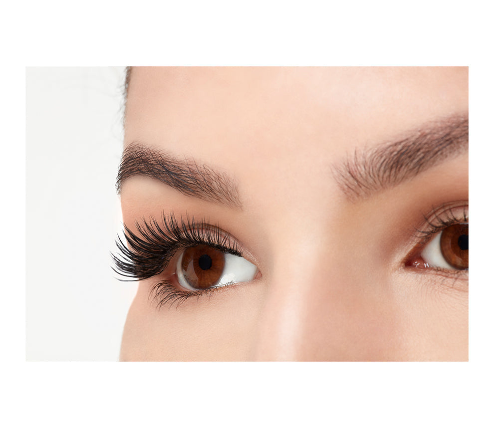 A model wearing Ardell Faux mink Demi Wispie in a side view emphasizing the curly, flared & natural lash look