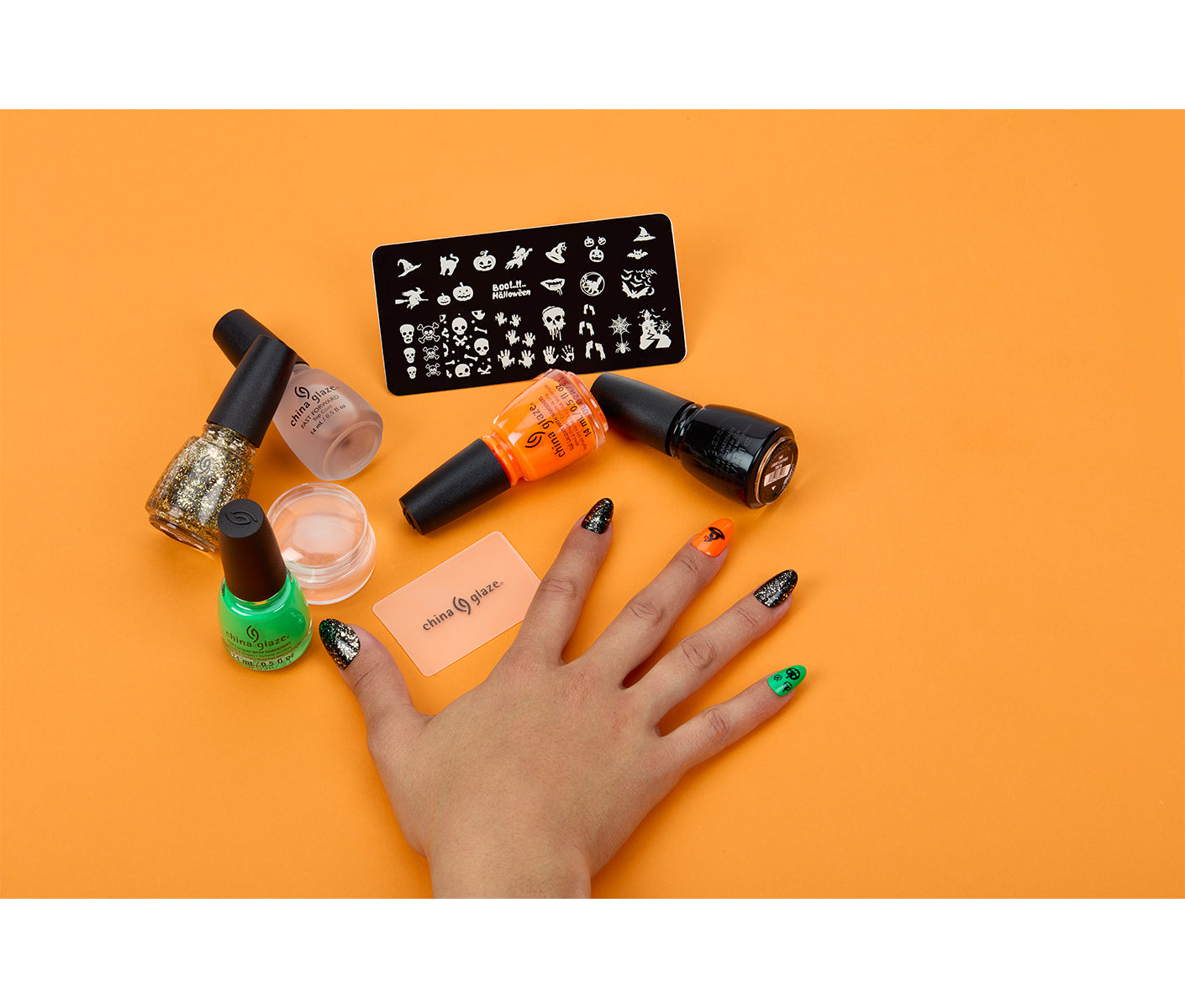 A woman's hand alongside China Glaze nail lacquer with  Nail Art Ghoulish Stamping Kit