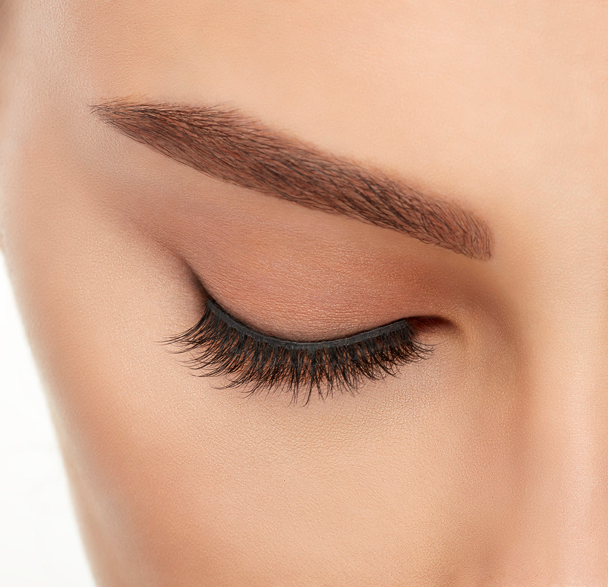 Close-up of a model&#39;s closed right eye wearing an Ardell Lift Effect 742 faux lash showing its curled round profile