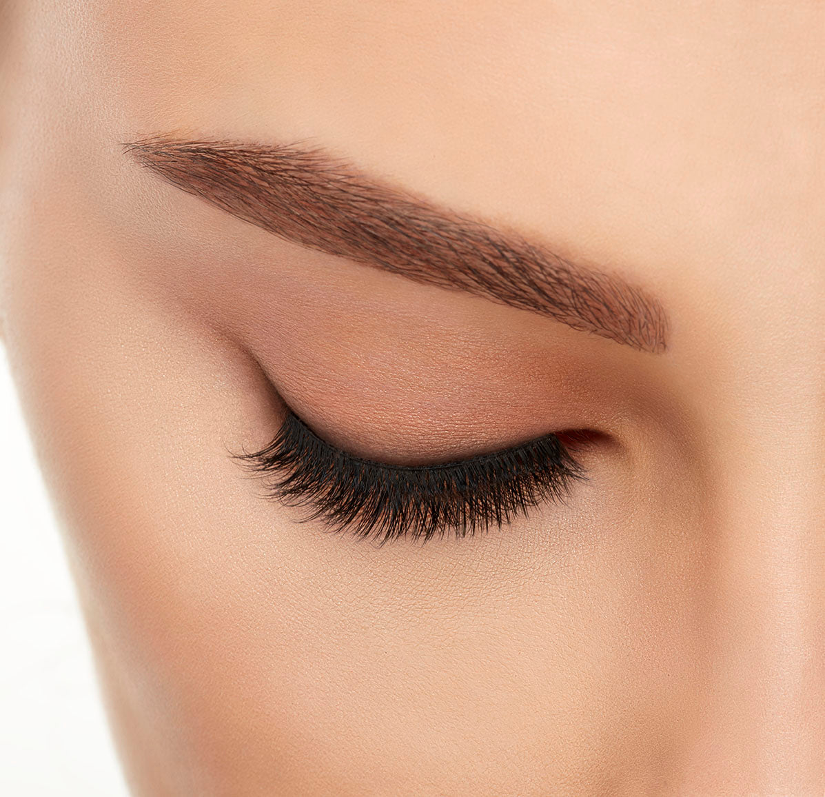 Close-up of a model&#39;s closed right eye wearing an Ardell Lift Effect 743 faux lash showing its soft tapered upswept fibers 