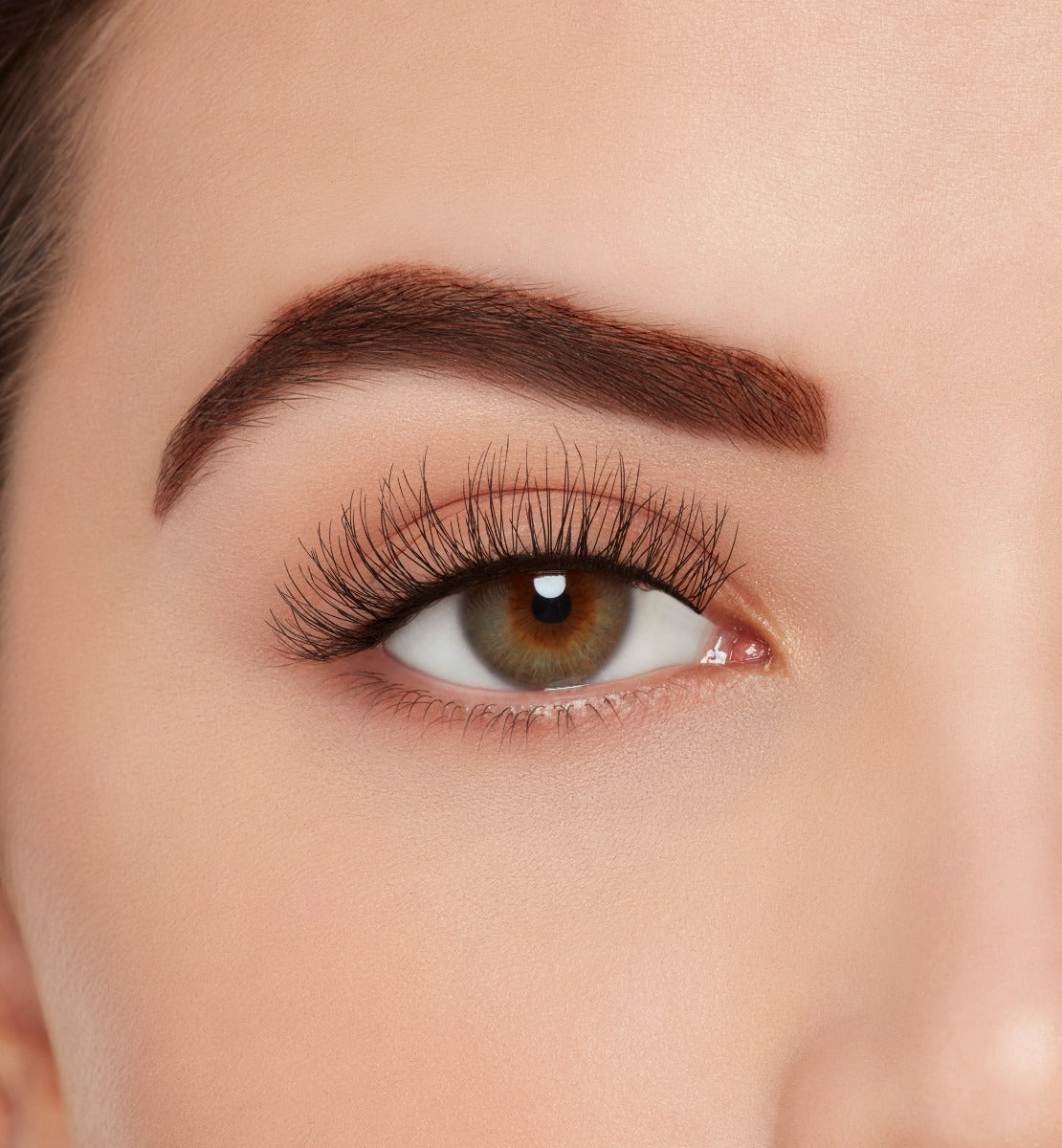 A model wearing Ardell's Ecolashes 450 with open right eye showing its extra-long layers with medium volume & fullness lash