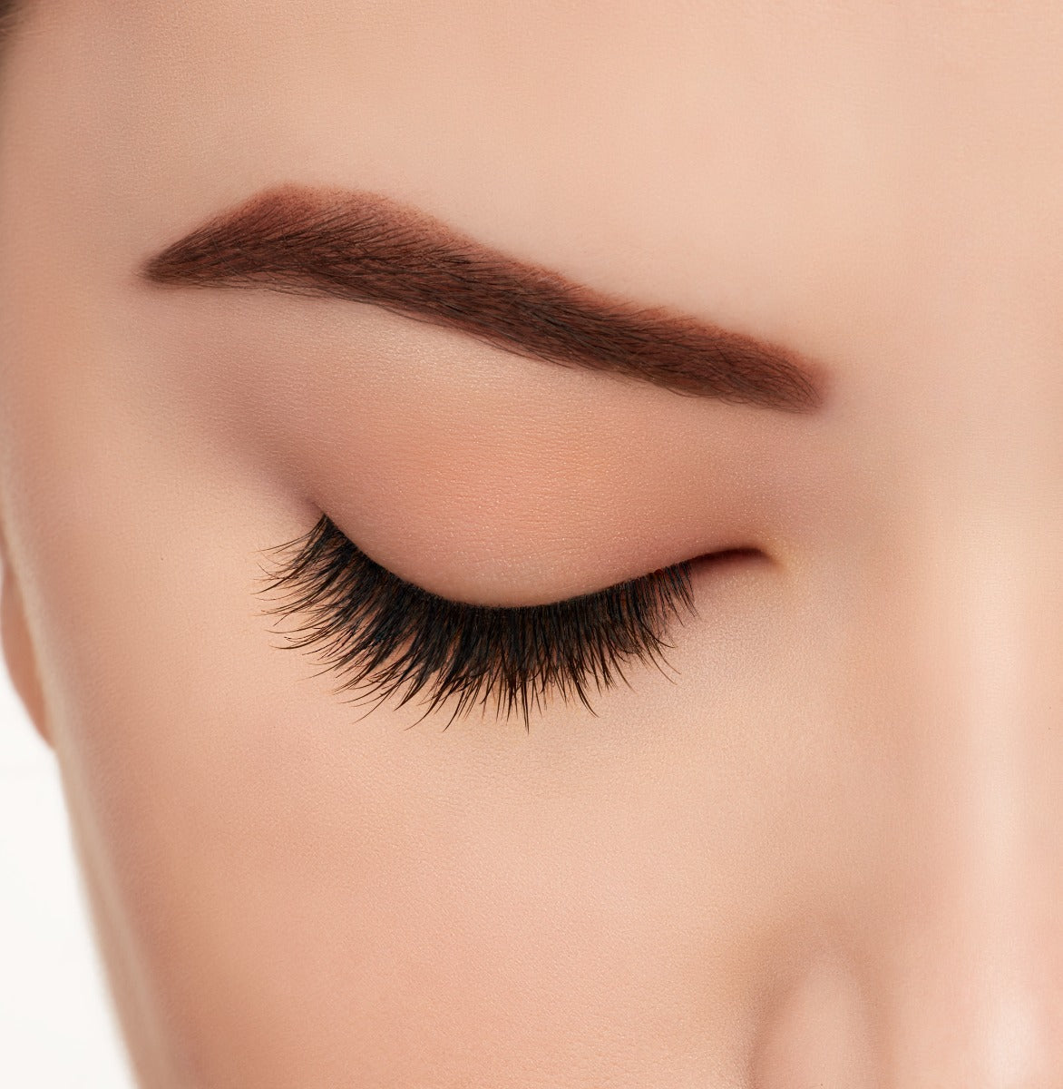 Ardell's Light As Air 521 on a closed right eye featuring its staggered lengths and light crisscrossing texture