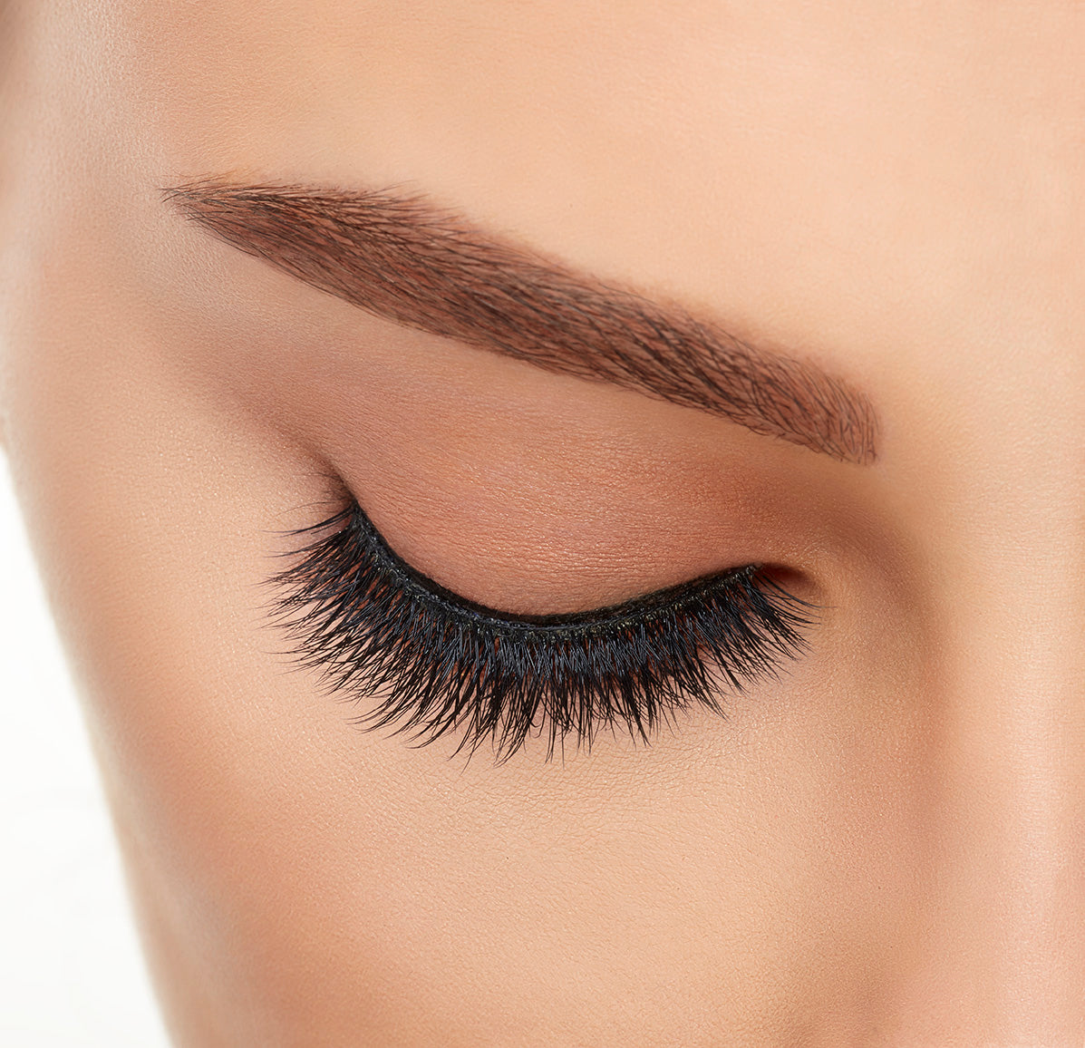 Close preview of a model's closed right eye wearing an Ardell Mega Volume 252 false lash showing its rounded silhouette