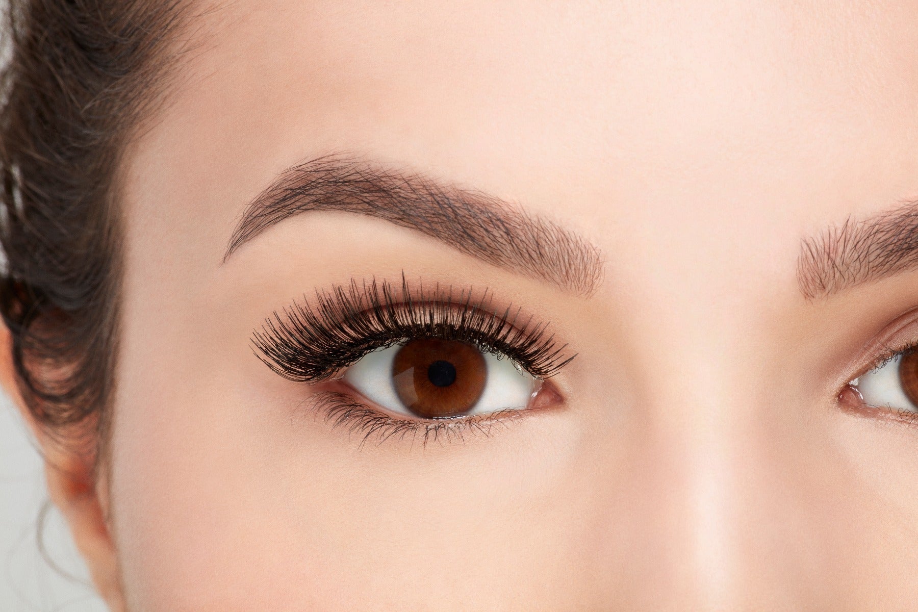 A model with an open right eye wearing Ardell Natural 105 showing its undetectable & totally natural look
