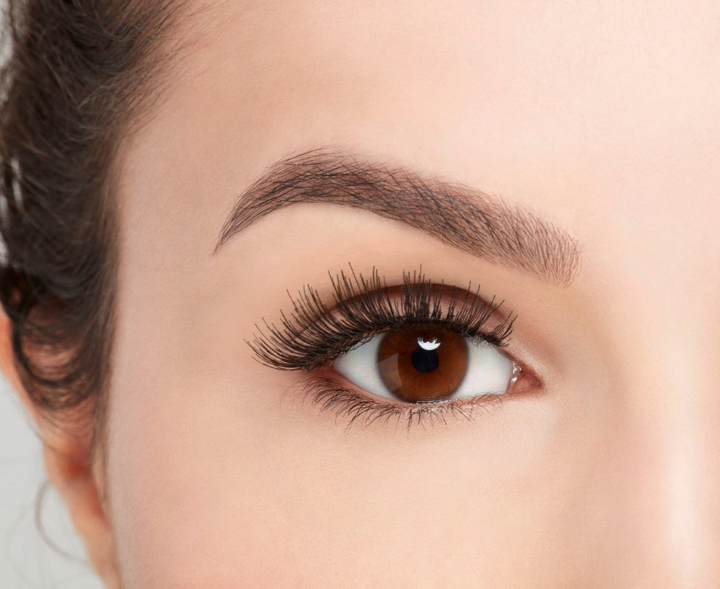 A model with an open eye wearing Ardell Studio Effects 230 showing its flared, long, curly & natural lash look