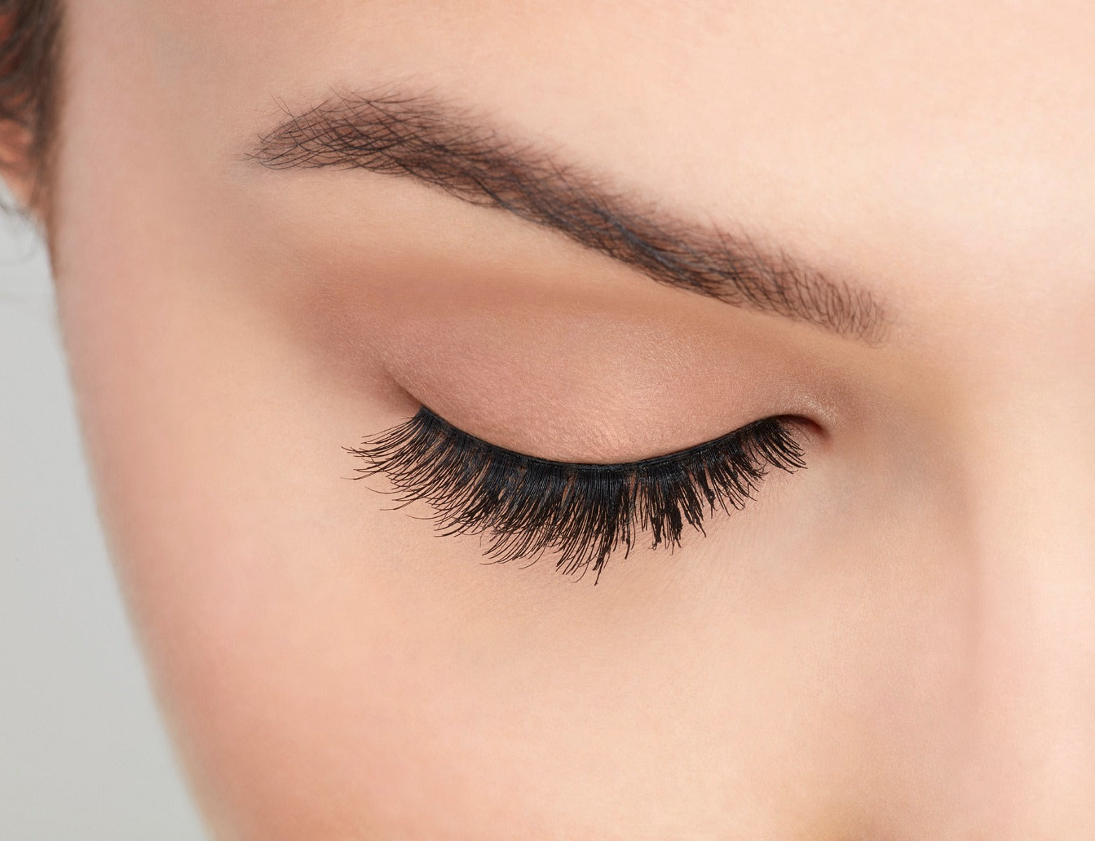 A model with closed eye wearing Ardell Studio Effects 230 with an accented full volume, curl & natural lash look