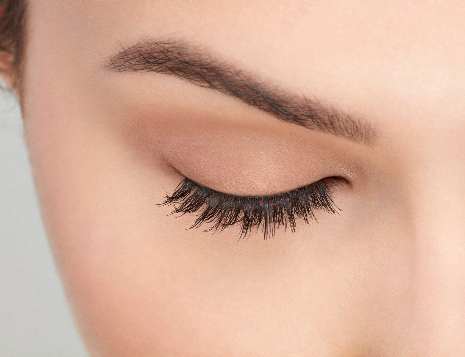 Close-up of a model's closed right eye wearing an Ardell Pre-cut Magnetic Lash 110 faux lash