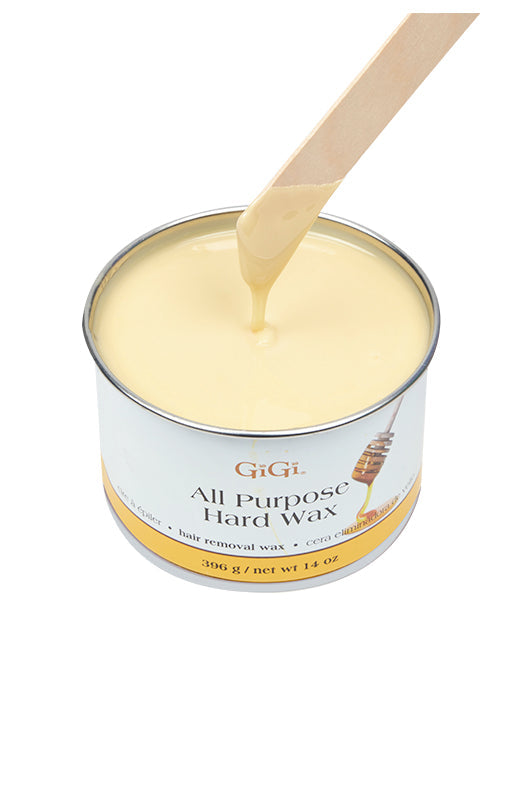 Applicator stick being drawn out of melted GiGi All Purpose Hard Wax in its can featuring its creamy white color & texture