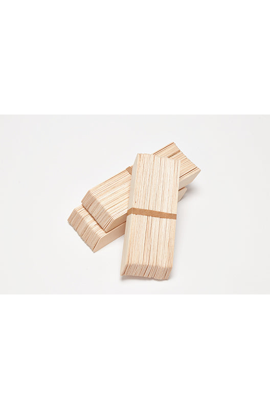 Stacked Wax Applicators – Multiple bundles of wooden waxing applicators, organized for professional or home waxing sessions.