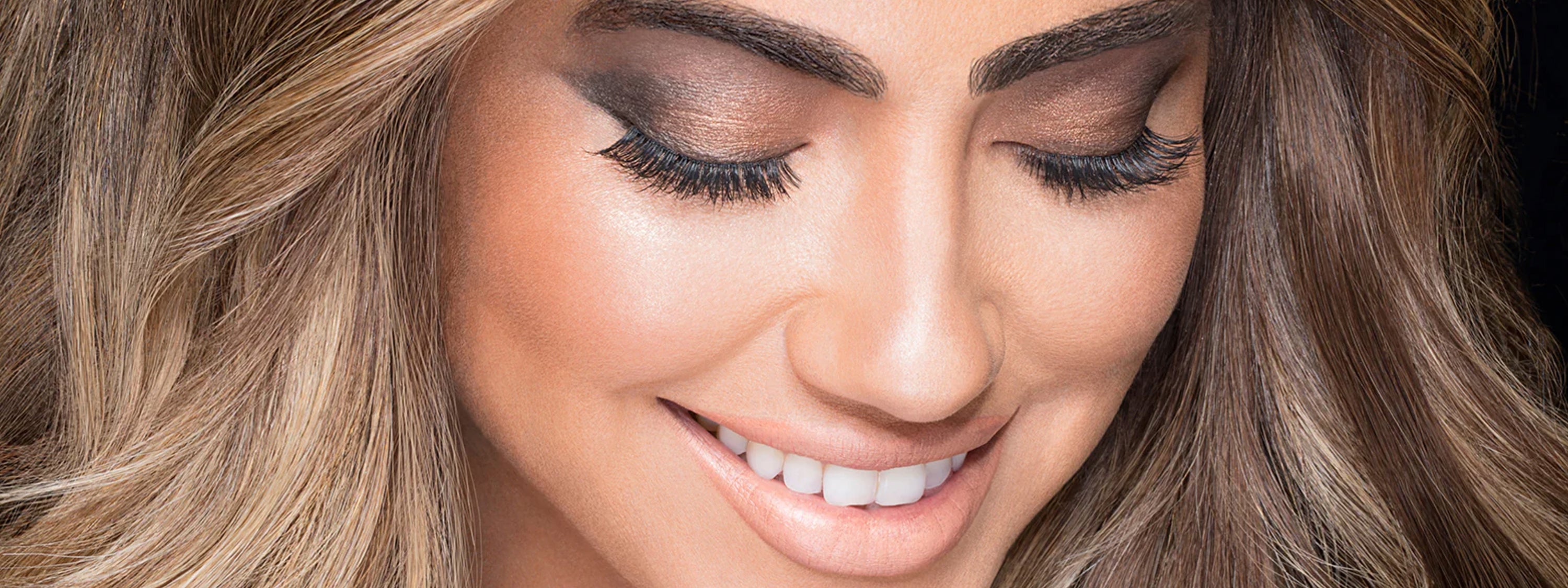 Close-up of a woman with long, wavy hair and makeup