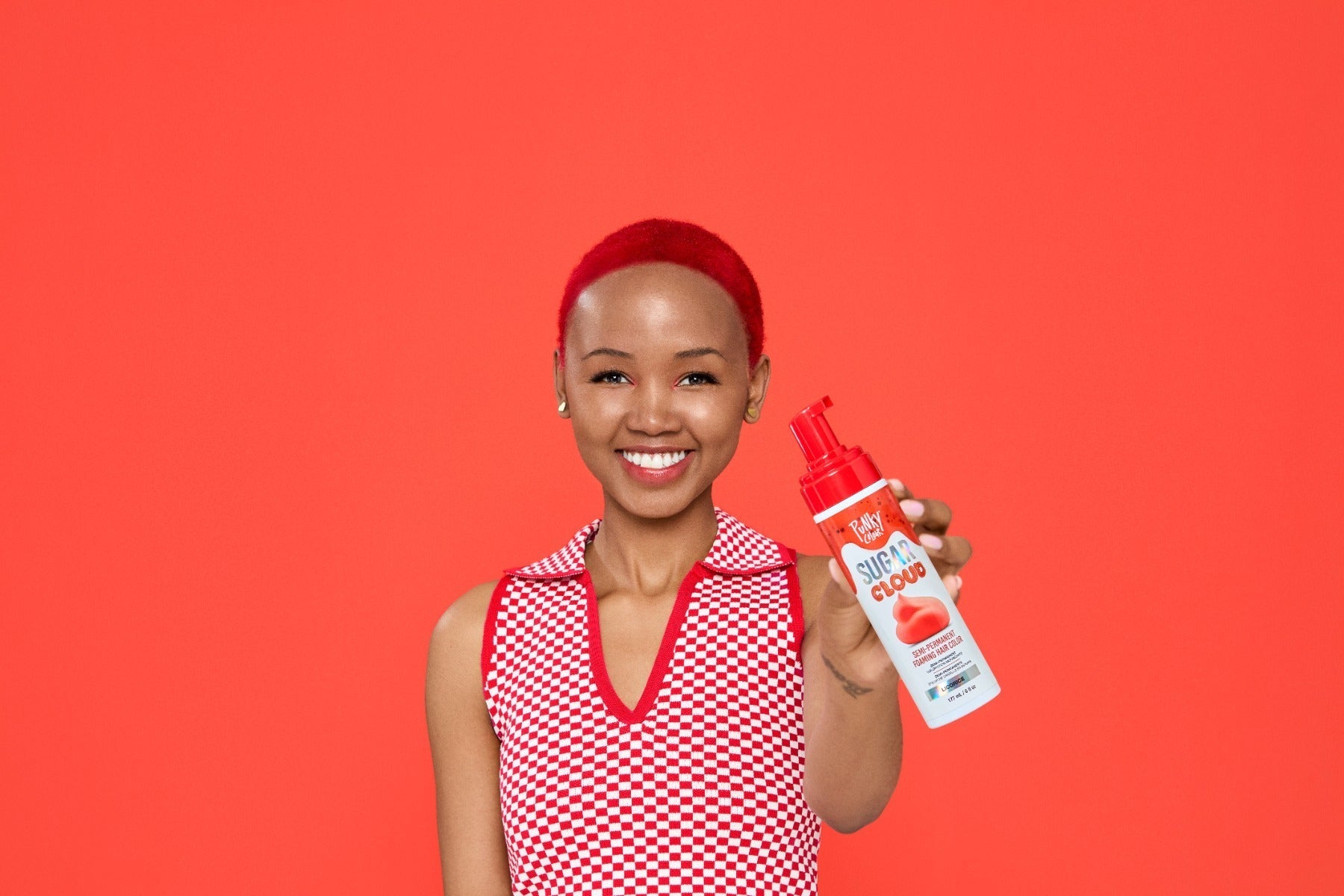 Model with red hair holding up a foam spray can of  Punky Colour Sugar Cloud Licorice Semi Permanent Foam Color
