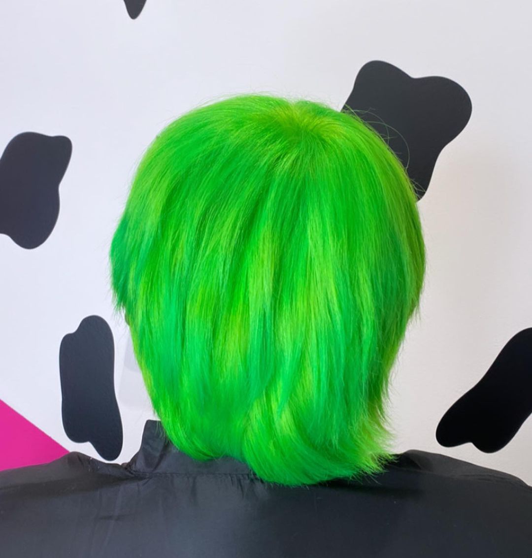 Vibrant Green Dyed Hair Back View – A model showcasing neon green hair from the back, featuring an even, bold, and bright dye application.