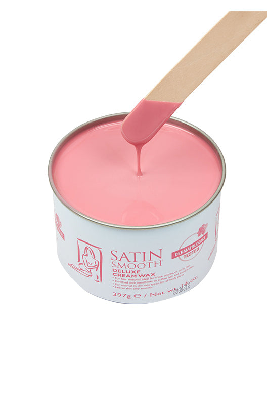 Dripping wax stick dipped into an open can of Satin Smooth Deluxe Cream Wax showing its full creamy rose pink color & texture